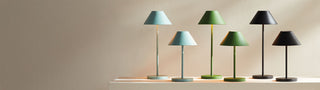Row of five rechargeable led lamps with different colored shades on a neutral background
